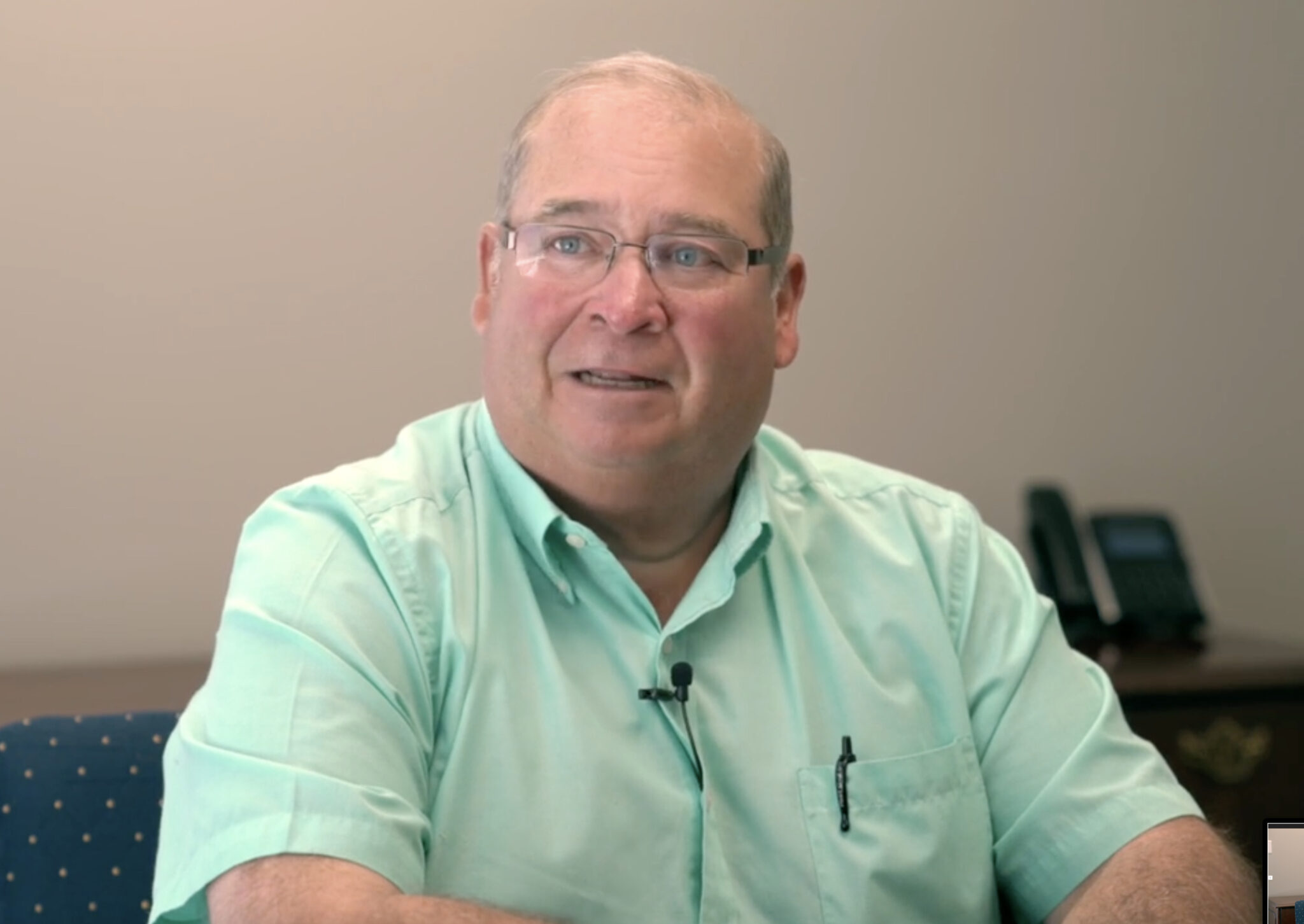 Real-life AMB client man wearing glasses and short sleeved green shirt.