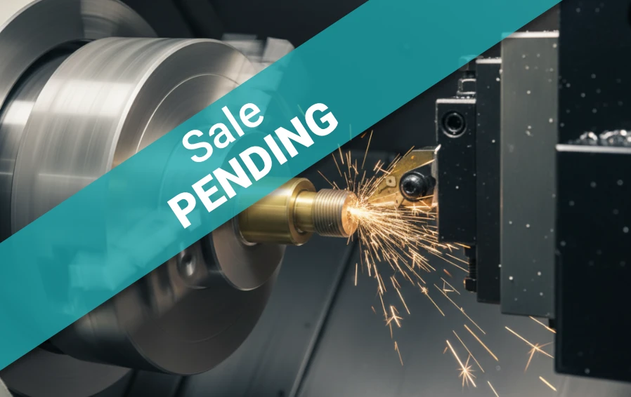 Precision CNC lathe machining a metal component with sparks flying — representing a Northeast-based manufacturer producing tight-tolerance parts for the defense and semiconductor industries, listed by Accelerated Manufacturing Brokers, Inc.